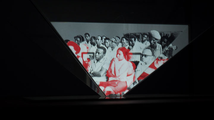 Ângelo Lopes (zusammen mit Rita Rainho), <i>Camarad(as)</i>, 2019, Vitrine, Glaspyramide, Spiegel, Videoprojektion, Foto: Associação Amigos do Museu do Cinema em Moçambique (AAMCM)